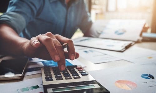 Person using calculator symbolizing IT spending