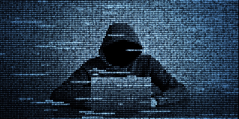 Hacker with computer symbolizing cyberattacks against Tech Service Providers, Microsoft Okta Lapsus$