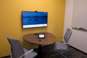 Huddle room in HealthStream headquarters. The room has a small table against a wall with two chairs on either side of it.