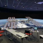 Office with display that shows a space station and part of the globe