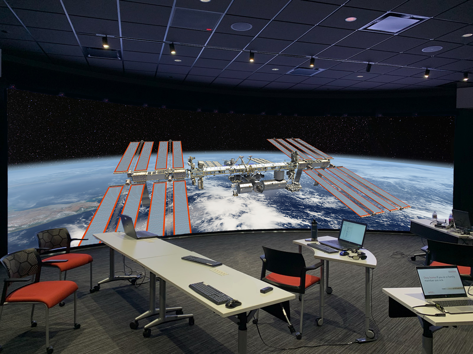 Office with display that shows a space station and part of the globe