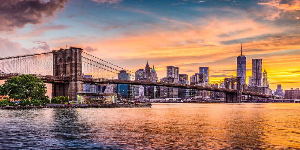 New York City skyline near Brooklyn Bridge at sunset.