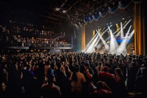 Side view of large audience enjoying a band performance.