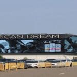 Screen displaying "American Dream" on road