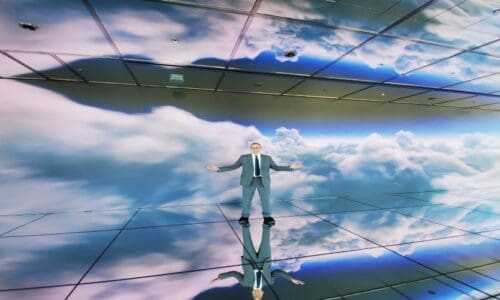 Person standing in front of a Samsung video wall displaying clouds.