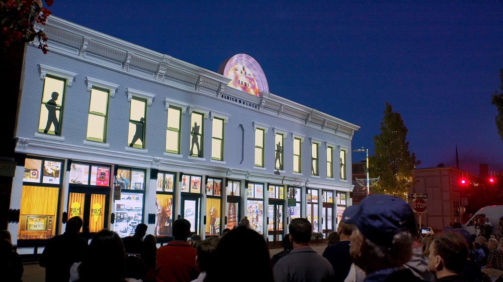 Building at night with projection displays on the windows.