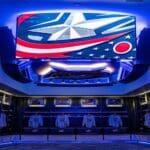 The SNA Displays center-hung feature hanging in the locker room. The screen has a display of the Blue Jackets logo