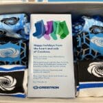 Socks with the Crestron logo inside a cardboard box.