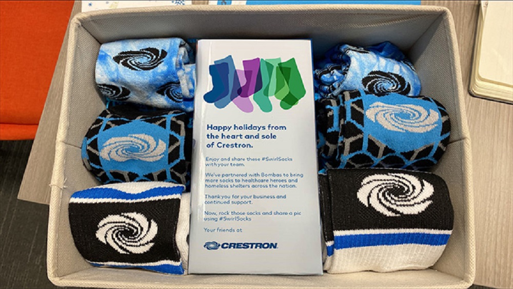 Socks with the Crestron logo inside a cardboard box.