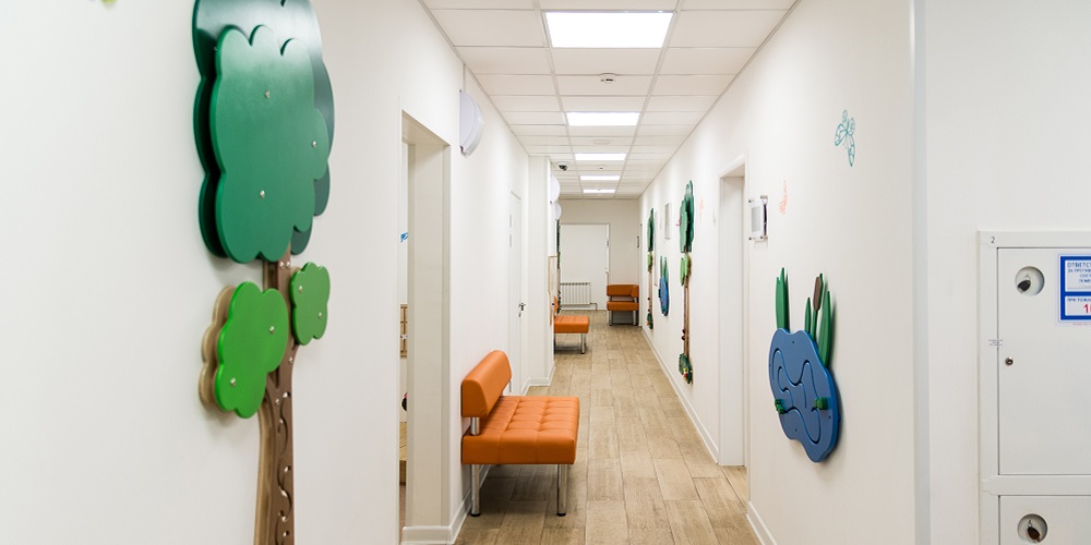 Corridor of children's hospital. Educational games hang on either side of the walls.