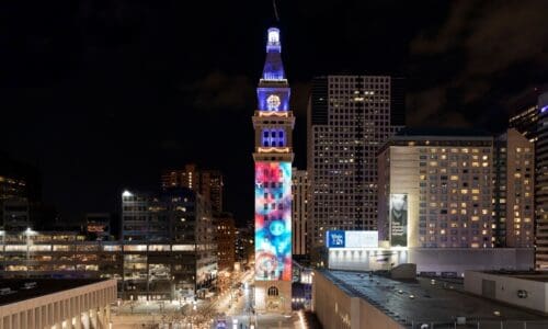 Digital Projection and Display Devices' projection on the clocktower. The projection features abstract shapes in blue, red and white.