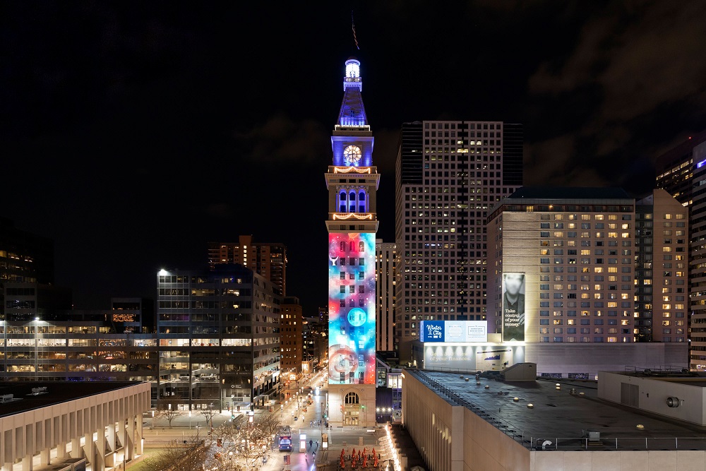 Digital Projection and Display Devices' projection on the clocktower. The projection features abstract shapes in blue, red and white.