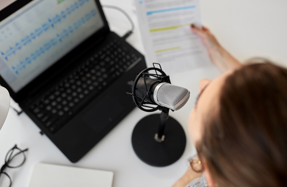 person with microphone recording podcast at studio.