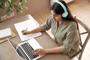 Student wearing headphones and taking an online-proctored exam.