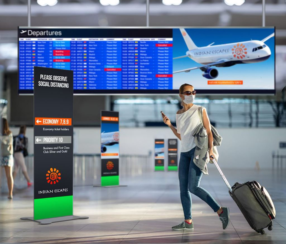 women traveling at airport with digital signage in background