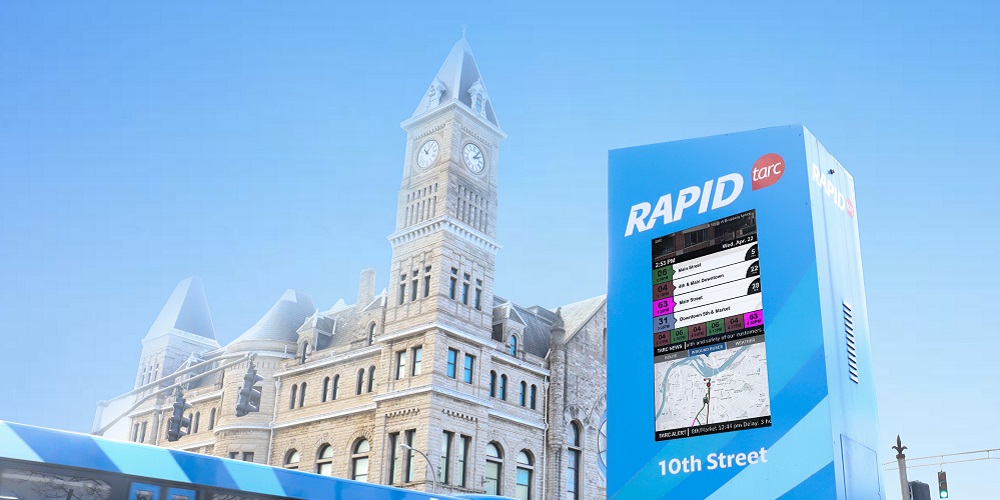 Red Dot/TARC's kiosk in front of a bus and building.