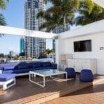 Cali Beach's deck with blue and white lounging chairs and table.