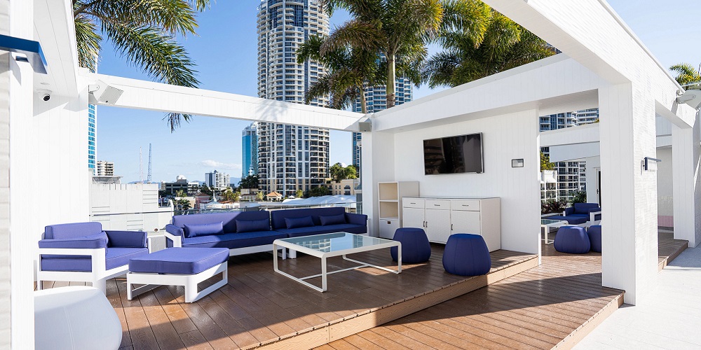 Cali Beach's deck with blue and white lounging chairs and table.