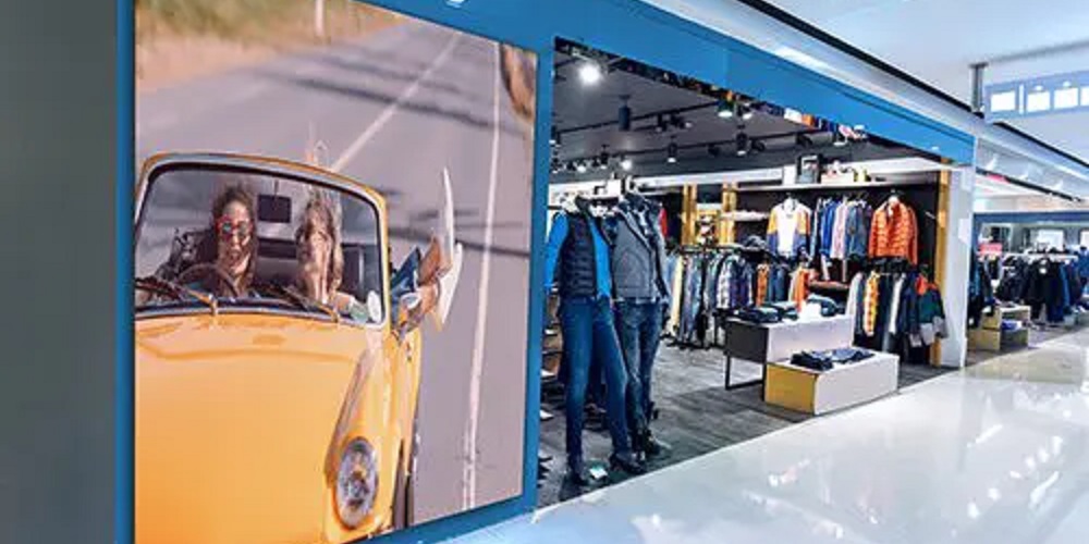 Clothing store displaying LED screen of people in a car.