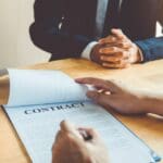 Business people negotiating a contract between two colleagues
