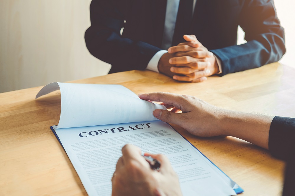 Business people negotiating a contract between two colleagues