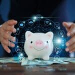 Person providing protection for cybersecurity money by holding a glass over a piggy bank.