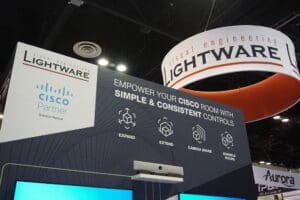 Lightware and Cisco partnership poster. Above the poster is a circular LED wall showing Lightware logo