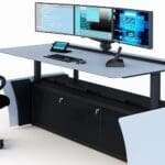 Chair and desk setup by Winsted and Concept Seating. On the desk are two monitors with a keyboard.