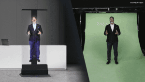 Person standing in front of a green screen with the person's hologram on the left.