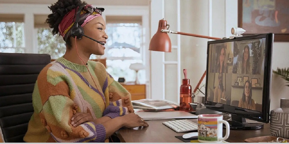 Employee wearing a Poly headset and attending a video meeting from home.