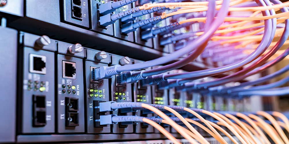 server rack with fiber optic cables attached to front panel switch ports.