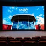 In an empty theater, the LG Curved DVLED display showcases image of Savoy Automobile Museum entrance.