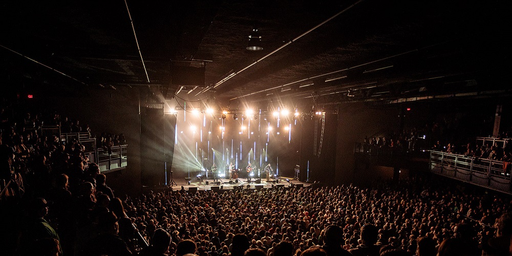 L-Acoustics system hanging overhead a crowded stage audience at Roadrunner.