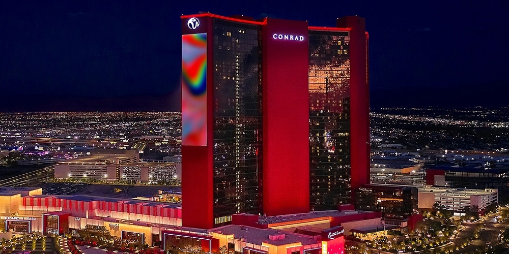 Resorts World Las Vegas bathed in red light at night.