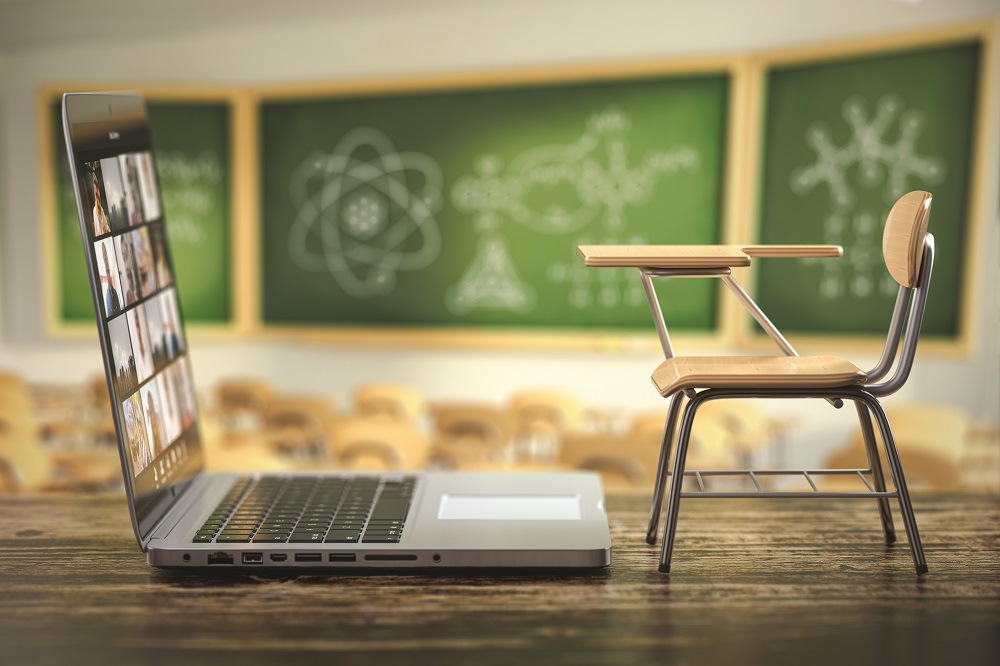 Laptop and school desk on blackdesk in classroom. Online education and e-learning concept. Home quarantine distance learning. 3d illustration