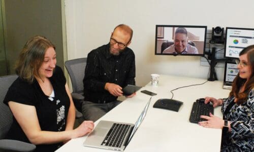 People using videoconferencing technology for communication at a meeting.