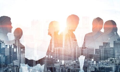 Double exposure shot of business people meeting on city office building in background depicting partnership success.