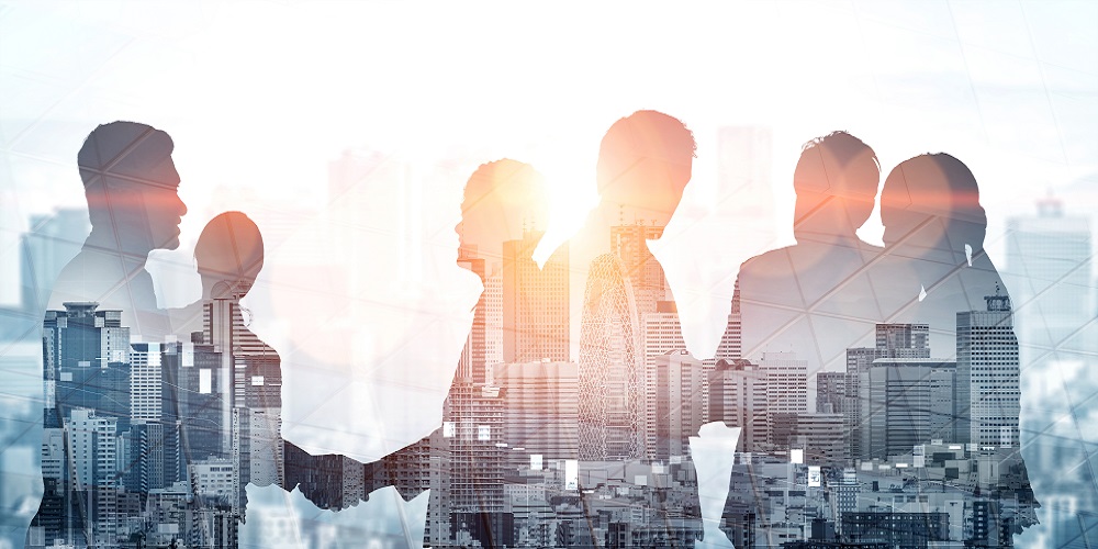 Double exposure shot of business people meeting on city office building in background depicting partnership success.