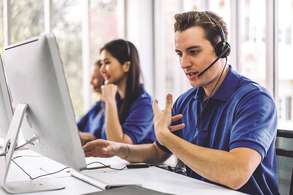 Group of happy call center smiling business operator customer support team phone services agen working and talking with headset on desktop computer at call center