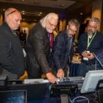 Attendees examining the E4 booth.