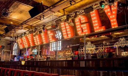 Coyote Ugly in marquee letters at the bar, above the letters are Renkus-Heinz speakers.