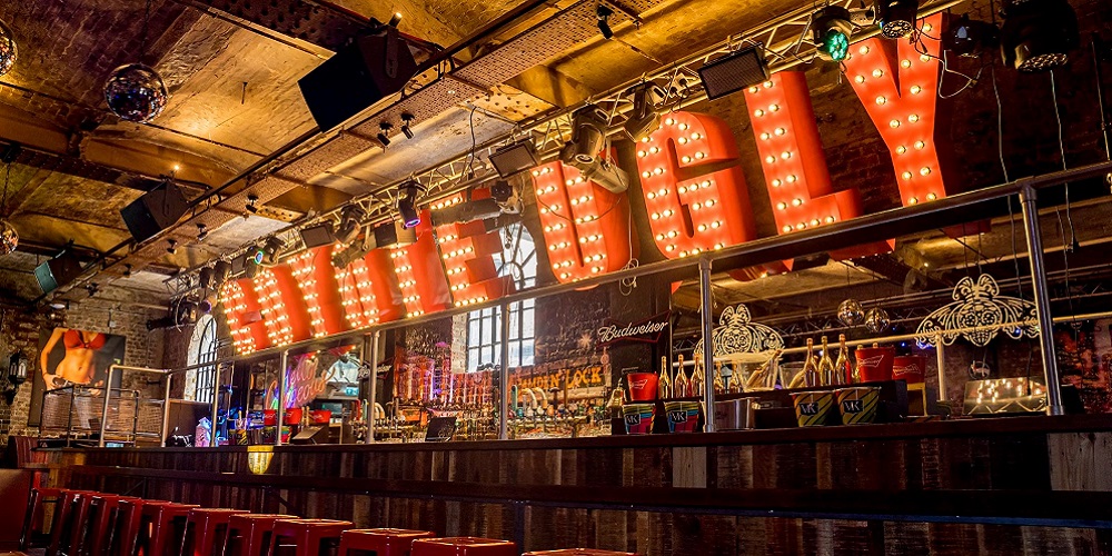 Coyote Ugly in marquee letters at the bar, above the letters are Renkus-Heinz speakers.