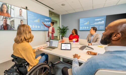 people sitting around large meeting room using Poly Studio Zoom Room bundle