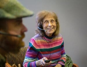 Senior citizen smiling while wearing a ListenTALK headset.