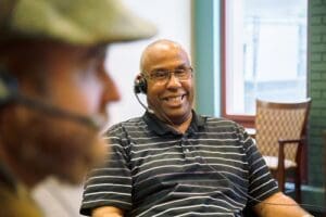 Senior citizen of Crown Center laughing while wearing the ListenTALK headset.