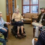 Senior citizens sitting in a circle at Crown Center and wearing ListenTALK headsets.