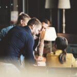 Group of young people in big office have a meeting and discussing company stats and sheets