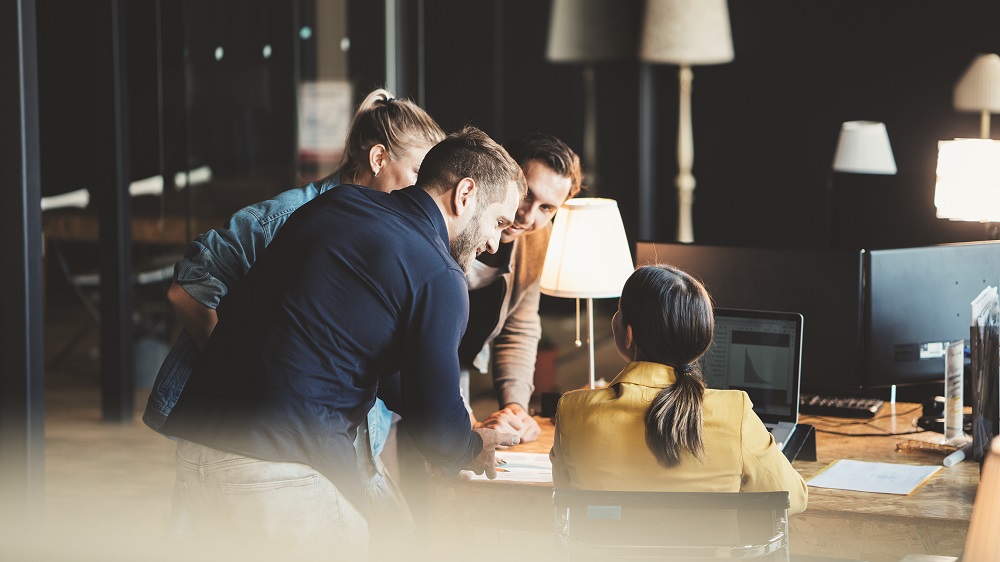 Group of young people in big office have a meeting and discussing company stats and sheets