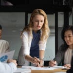 woman looking a budget on conference room table, teach research, team planning