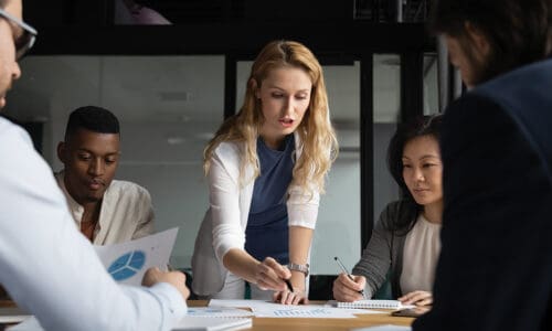 woman looking a budget on conference room table, teach research, team planning